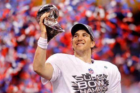 Eli Manning lifting the Super Bowl trophy