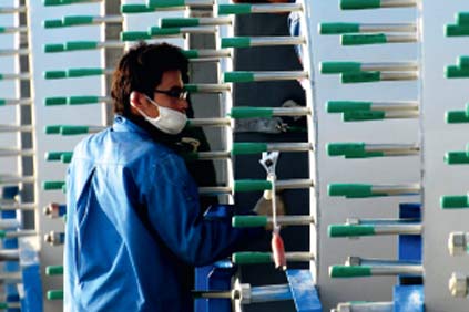 A techician examines turbine blades in Jinquan plant, in Gansu
