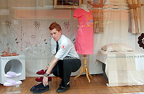 A Red Cross Volunteer mans a charity shop