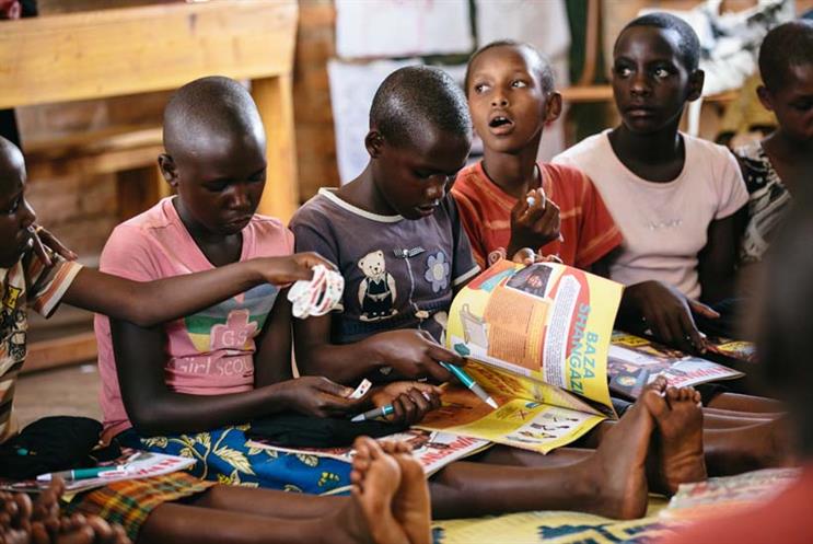 Girls enjoying Ni Nyampinga magazine, which reaches 100,000 girls across Rwanda