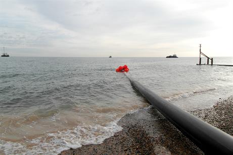 One of the pipes being pulled by tug boats from the beach