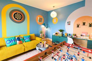 Bright living room with table football and yellow sofa 