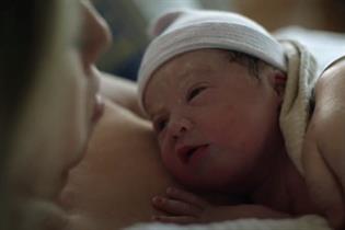 Still from ad showing a mother holding her newborn baby