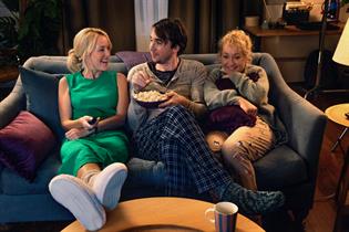 Gillian Anderson sits with a couple on their sofa in BT's latest TV ad