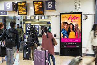 An Afro Hair and Beauty digital billboard at a train station