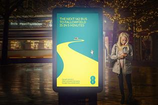 woman at a bus stop with an EE ad giving details of the safest way home