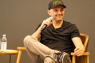 Gary Vaynerchuk sat in a chair, holding a microphone to his mouth.