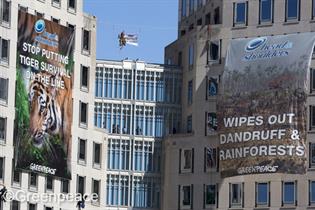 Greenpeace: activitsts hang P&G ad parodies from the company's headquarters