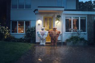 An Ikea ad showing two bears with muscles guarding a front door to a house