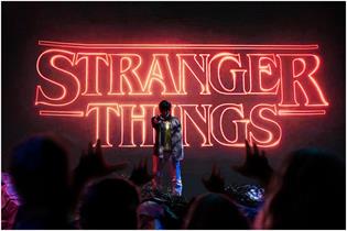 Crowd reaches towards Stranger Things character on stage 