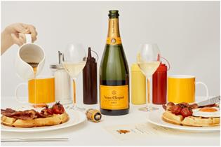 two plates of brunch waffles with a bottle of Veuve Clicquot