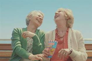 Two women laughing on a bench