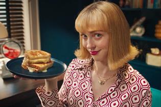 Woman holding plate with a cheese toasty on it