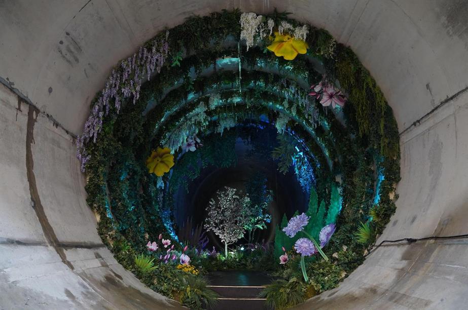 Photo of "Loo Gardens", an installation appearing as a garden lining the walls of a large sewage tunnel