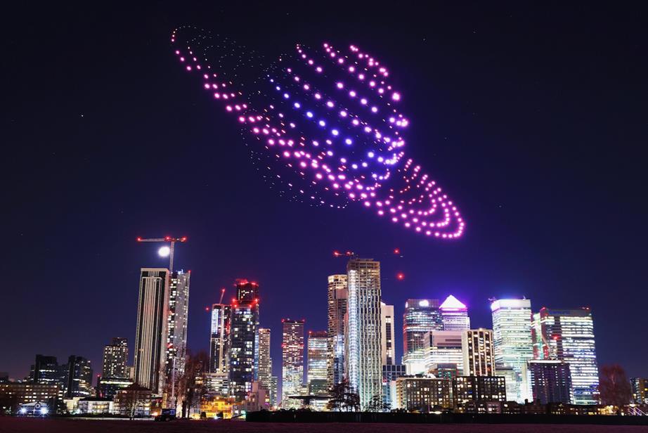 A drone light show over London, with a gigantic spaceship lighting up the sky