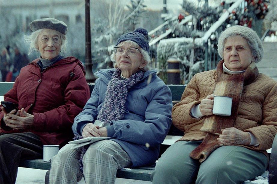 A still from the ad showing three women sitting together on a park bench