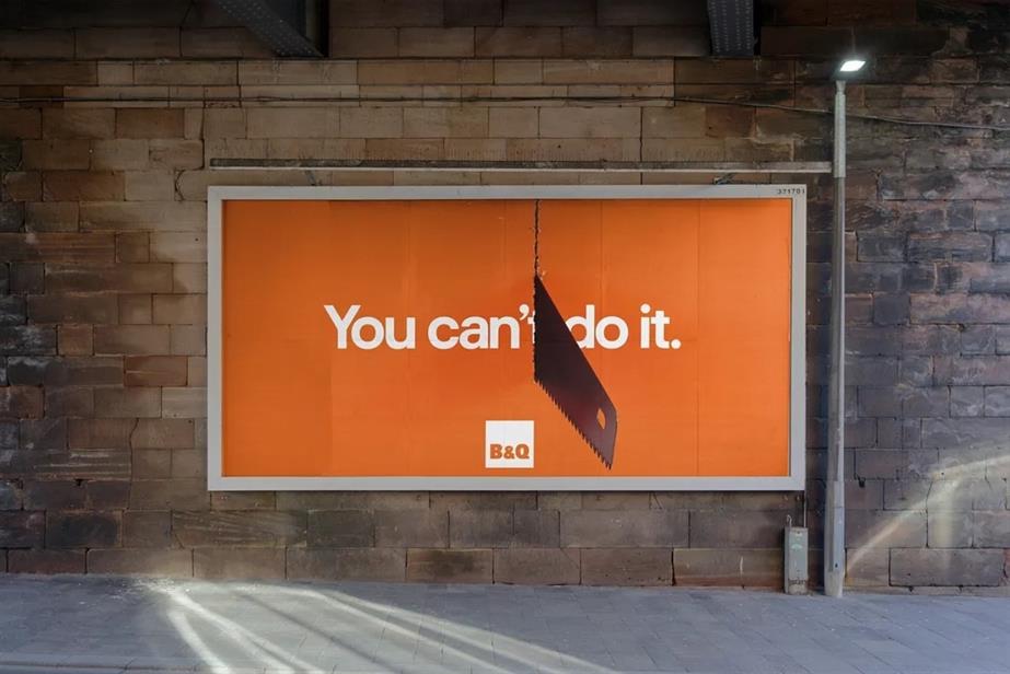 A billboard which says "You can't do it" with a hand saw that cuts the tagline in half.