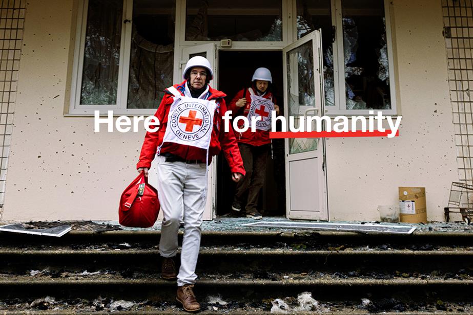 British Red Cross social ad, an image of a responder in a disaster-struck country, and copy reading 'Here for humanity'