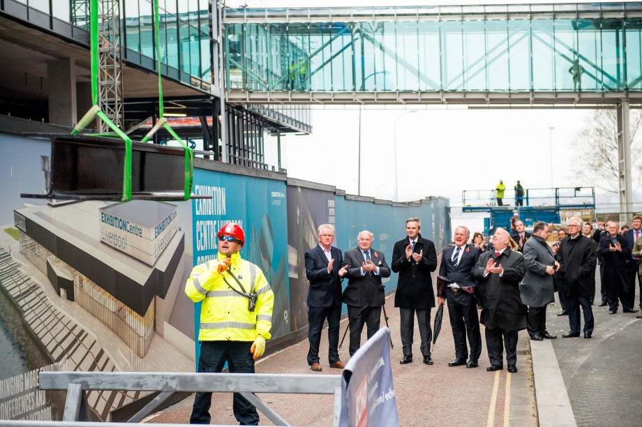 Attendees watch as the beam is lifted