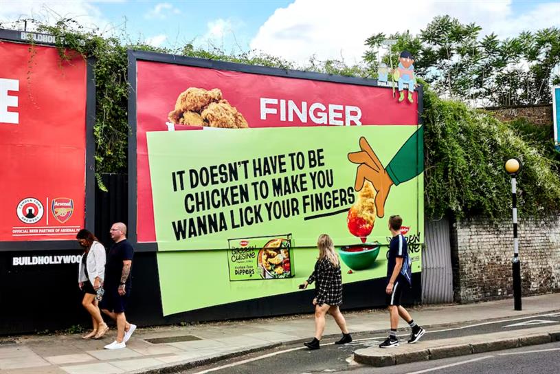 A billboard for Green Cuisine pasted over an ad for KFC.