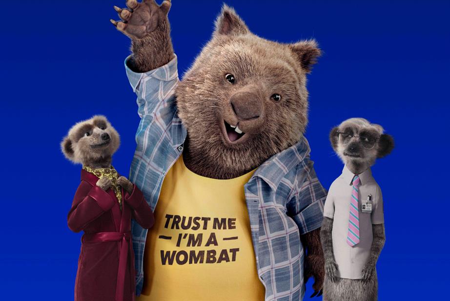 Meerkats standing with a wombat