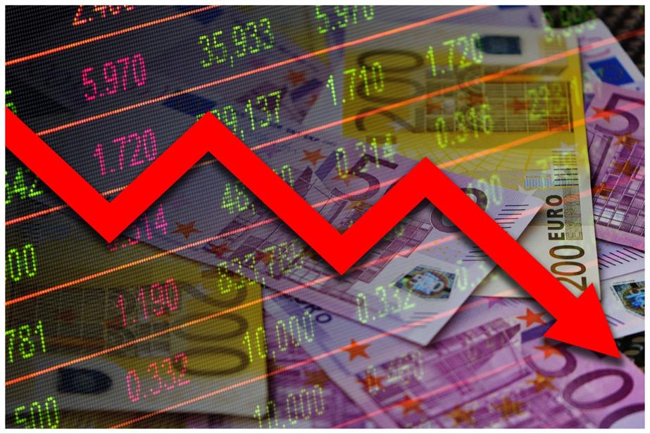 Red graph line going down against background of currencies