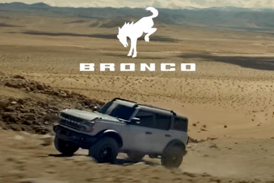 Image of a Ford Bronco travelling through a desert.