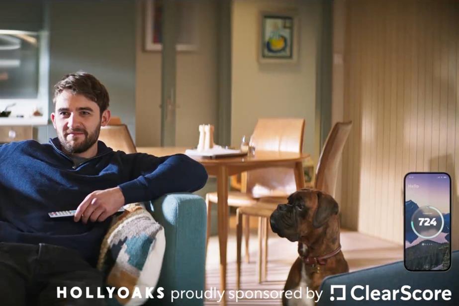 A man sits on the sofa watching the TV as his dog looks at him.