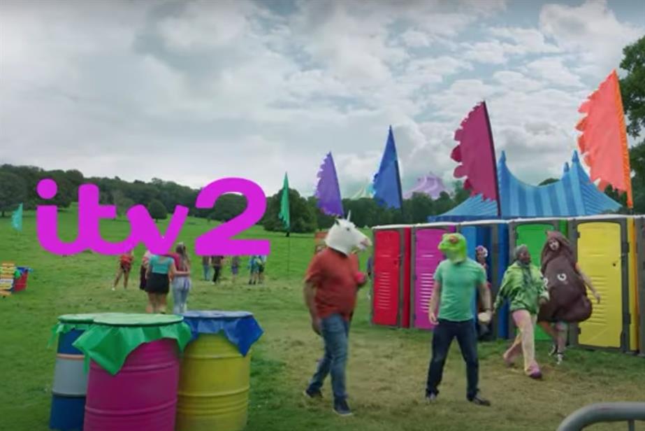 A still from ITV2's ident, showing a park scene in which festivalgoers are wearing animal masks