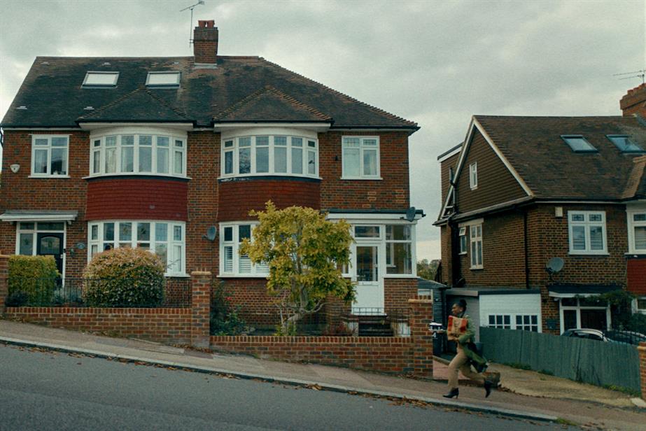 A woman struggles home carrying a KFC takeout