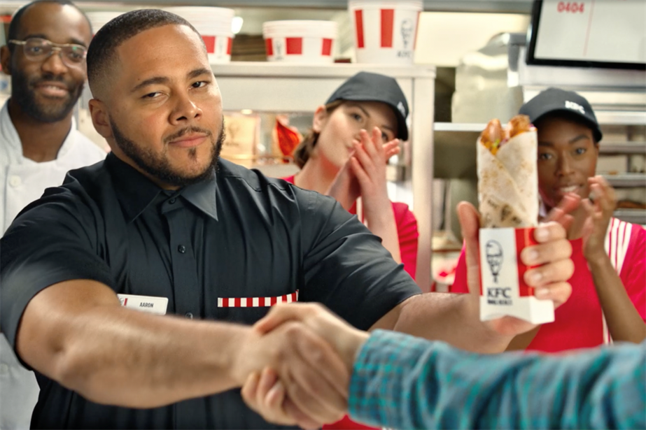 A still from the KFC ad showing a server shaking a customer's hand