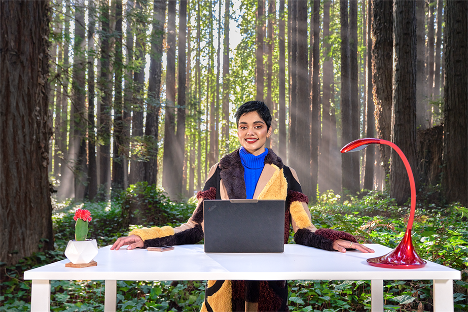 A lady sitting in a desk in the forest with Lenovo's new ThinkPad ZSeries laptop