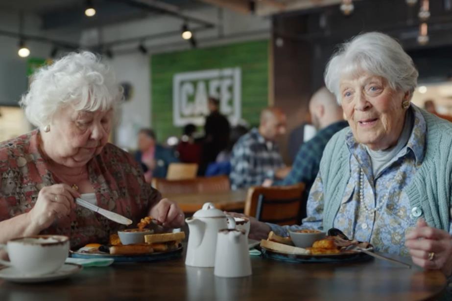 Two older women sit in a Morrisons cafe, talking to the camera. 