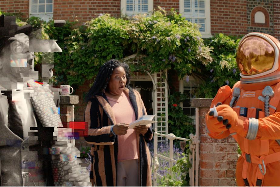 A woman looks shocked as she reads a letter next to an astronaut