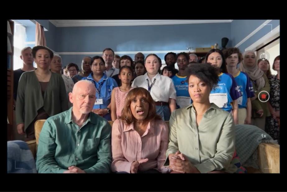 Family sitting on sofa surrounded by support staff