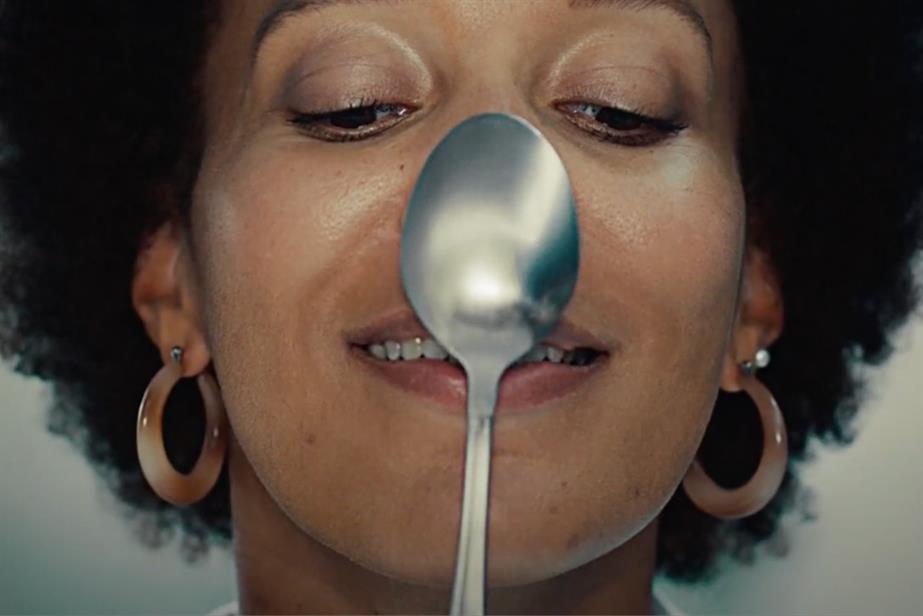 Woman with spoon balancing on her nose