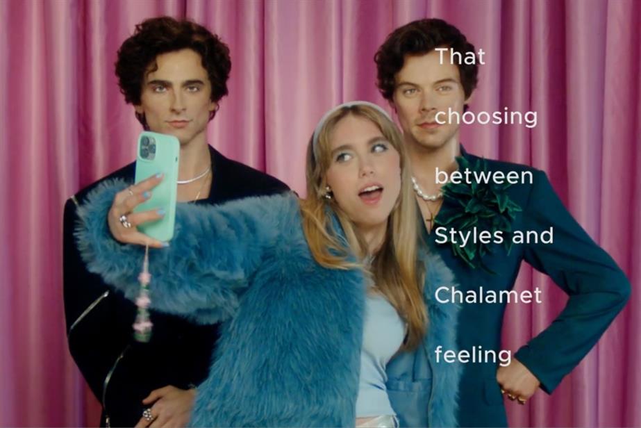 Woman taking selfie with Timothee Chalamet and Harry Styles wax figures