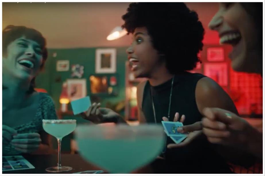 Three women playing a board game and drinking tequila cocktails