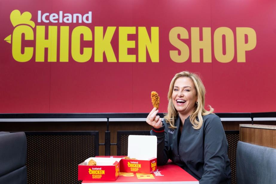 Josie Gibson sat at an Iceland table holding piece of fried chicken