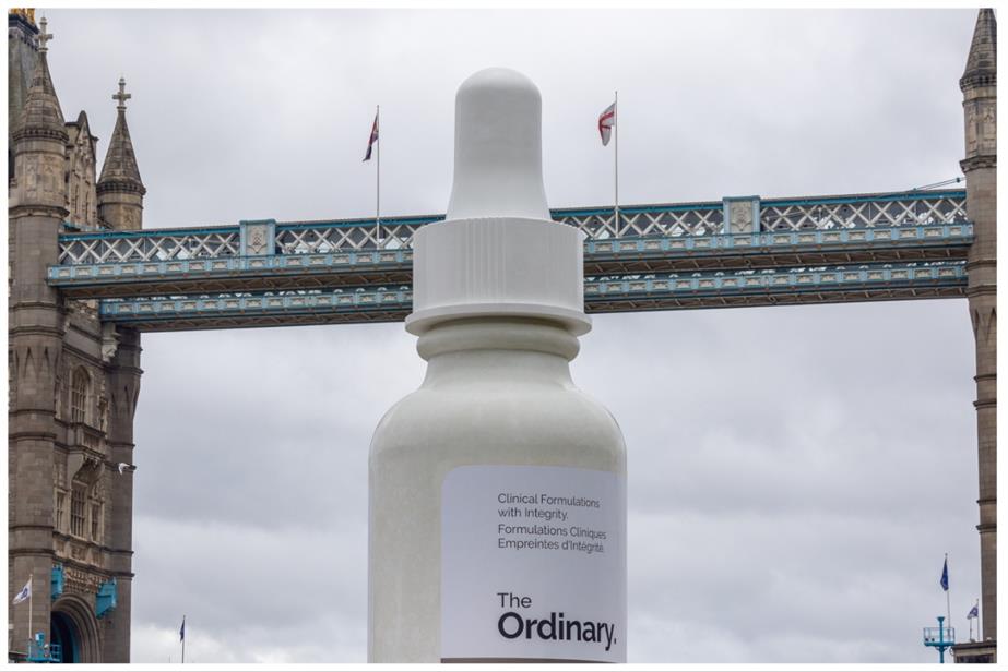 The Ordinary bottle floating under Tower Bridge