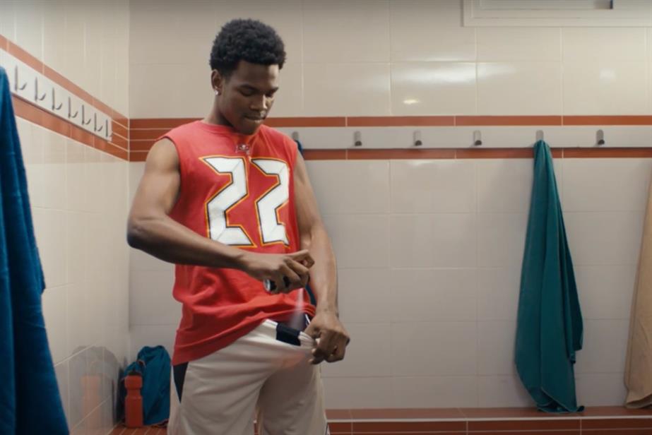 Man spraying Lynx down his boxers wearing a red t-shirt