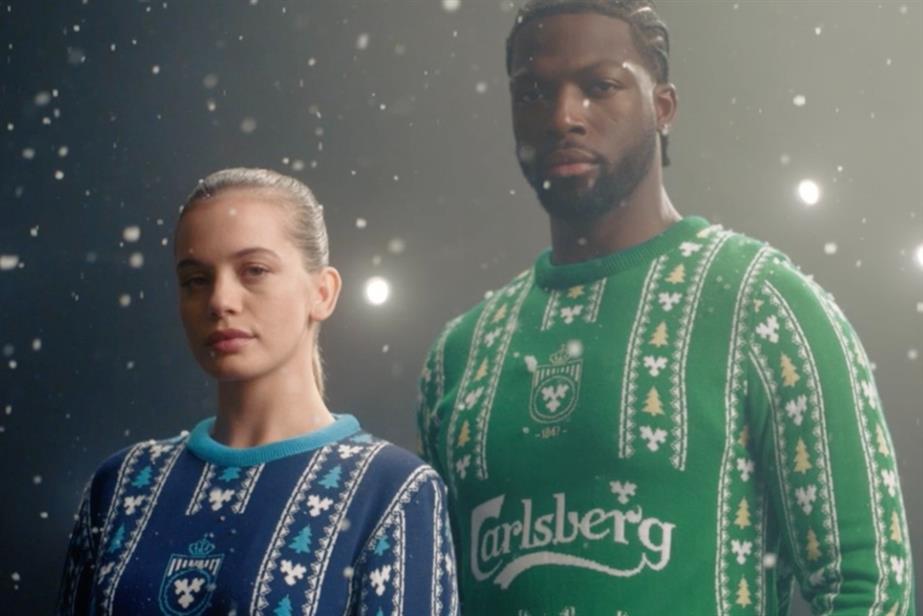 man and woman wearing Christmas jumpers