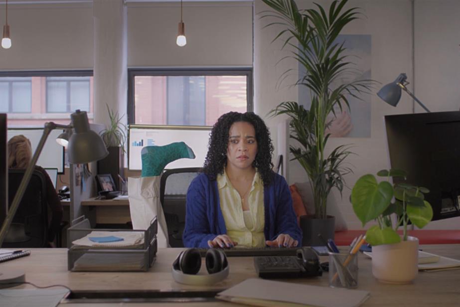 Woman working at a desk with foot talking to her