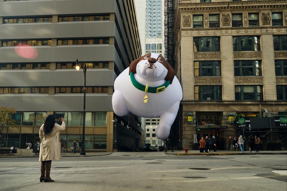 giant dog balloon stuck between buildings