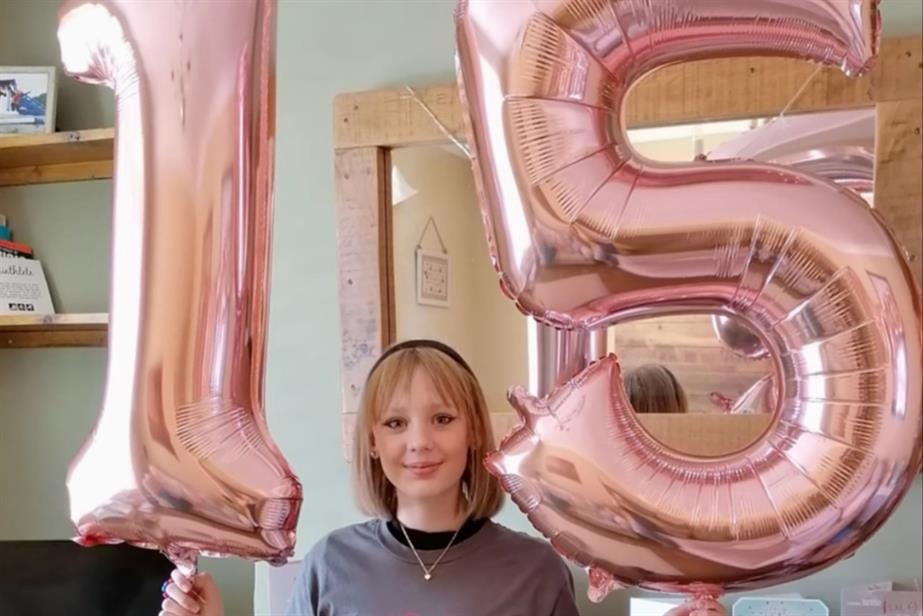 Picture of young girl standing with 15th birthday balloons