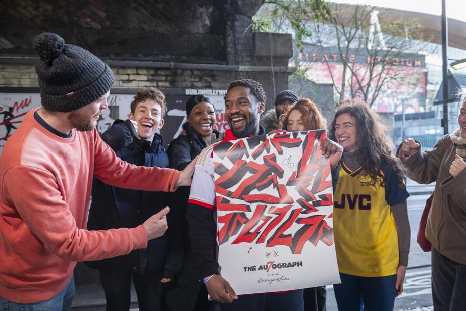 Arsenal's Buyako Saka holds up a signed football shirt