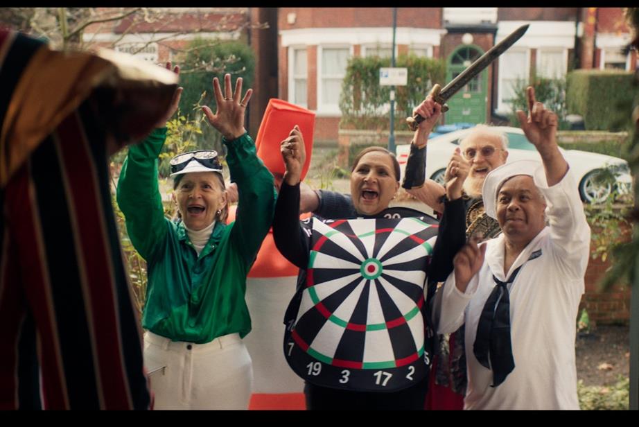 Still from the ad showing a groups of people in fancy dress