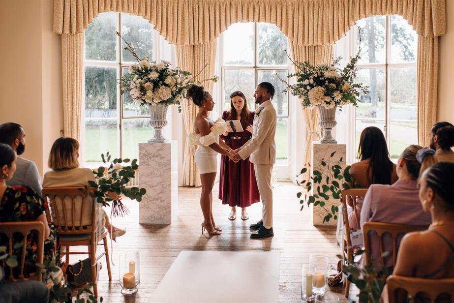 A couple stands in front of their wedding guests ready to make their vows