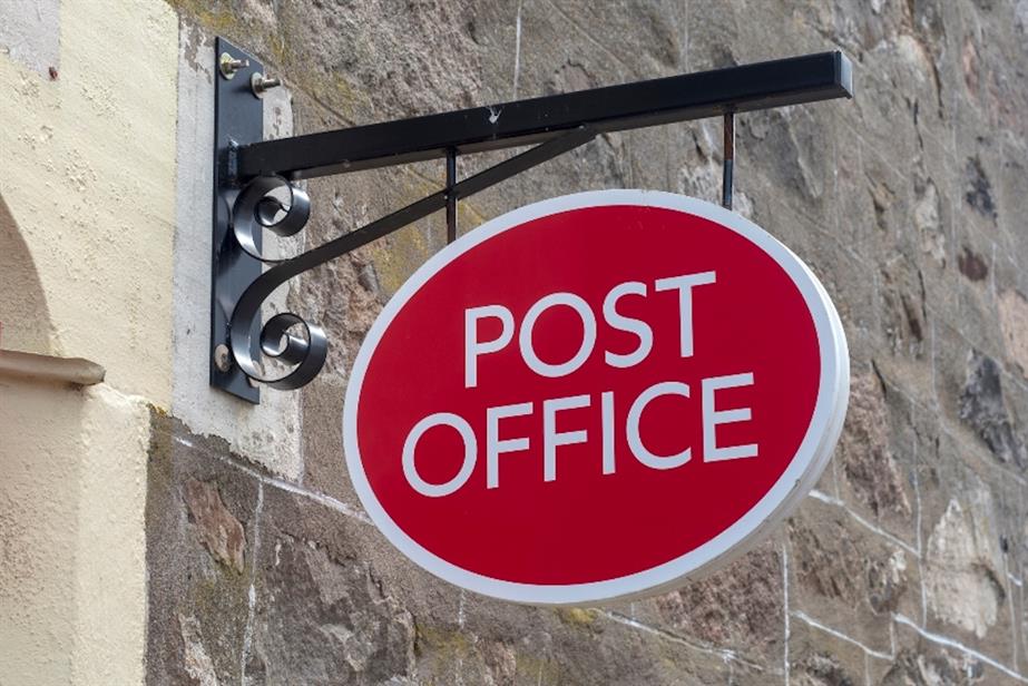 Post office sign outside stone wall (©GettyImages)