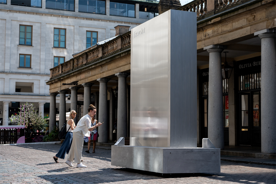 A picture of Revolut's installation in Covent Garden showing a woman pointing her mobile at the QR code